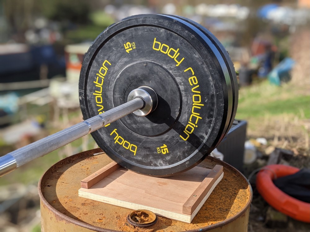 barbell with "body revolution" plates in sunshine